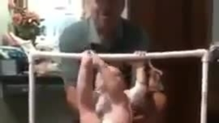 Baby atleta si esercita alla sbarra