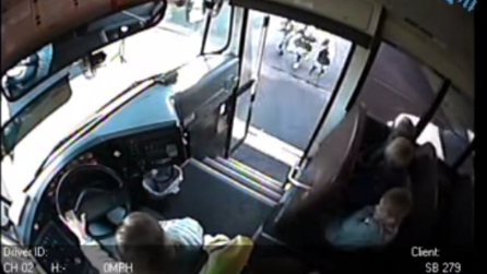 I bimbi stanno per salire sullo scuolabus quando un'auto passa a tutta velocità